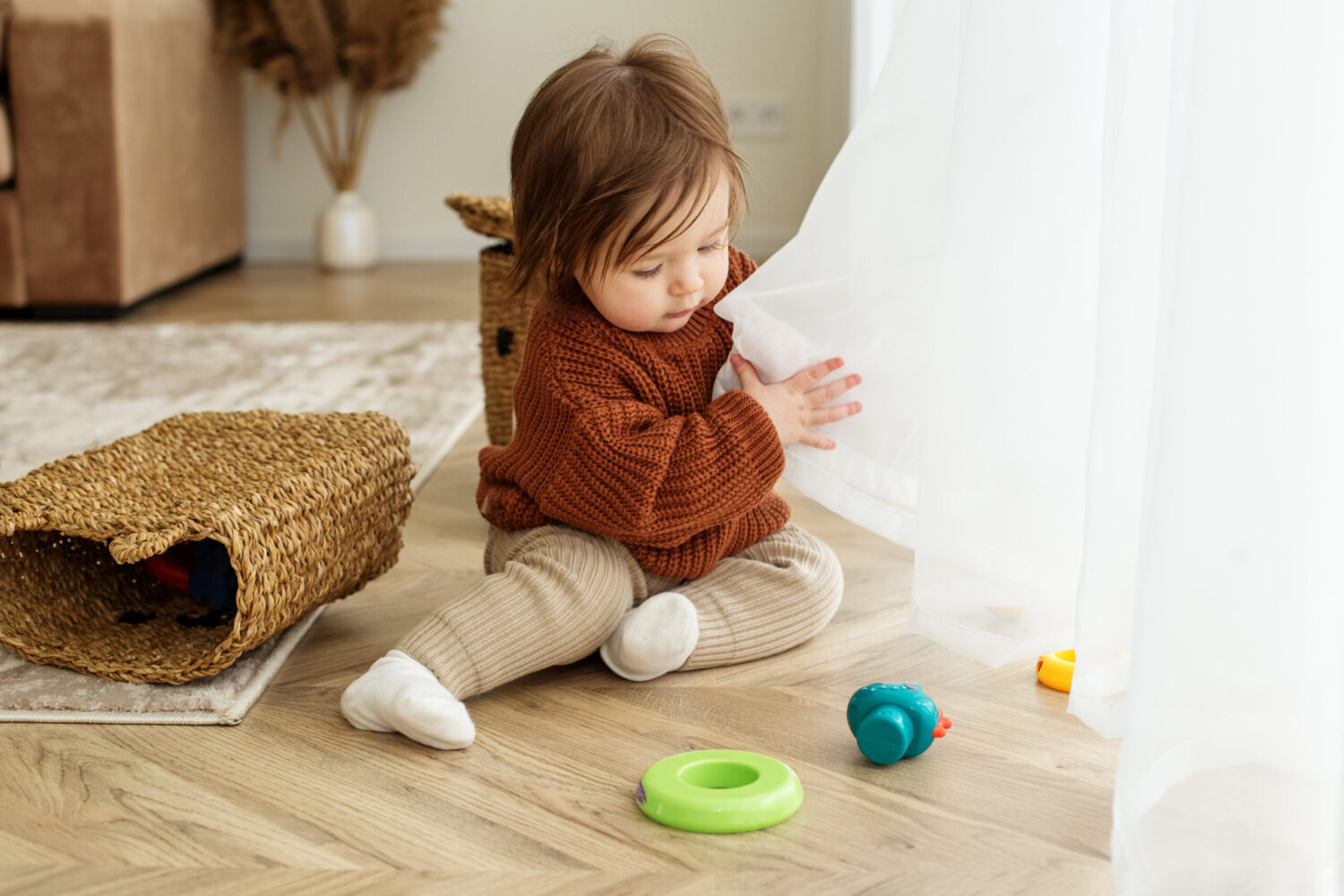 Toddler child is playing with toys on floor in room. Childhood, kindergarten and development concept